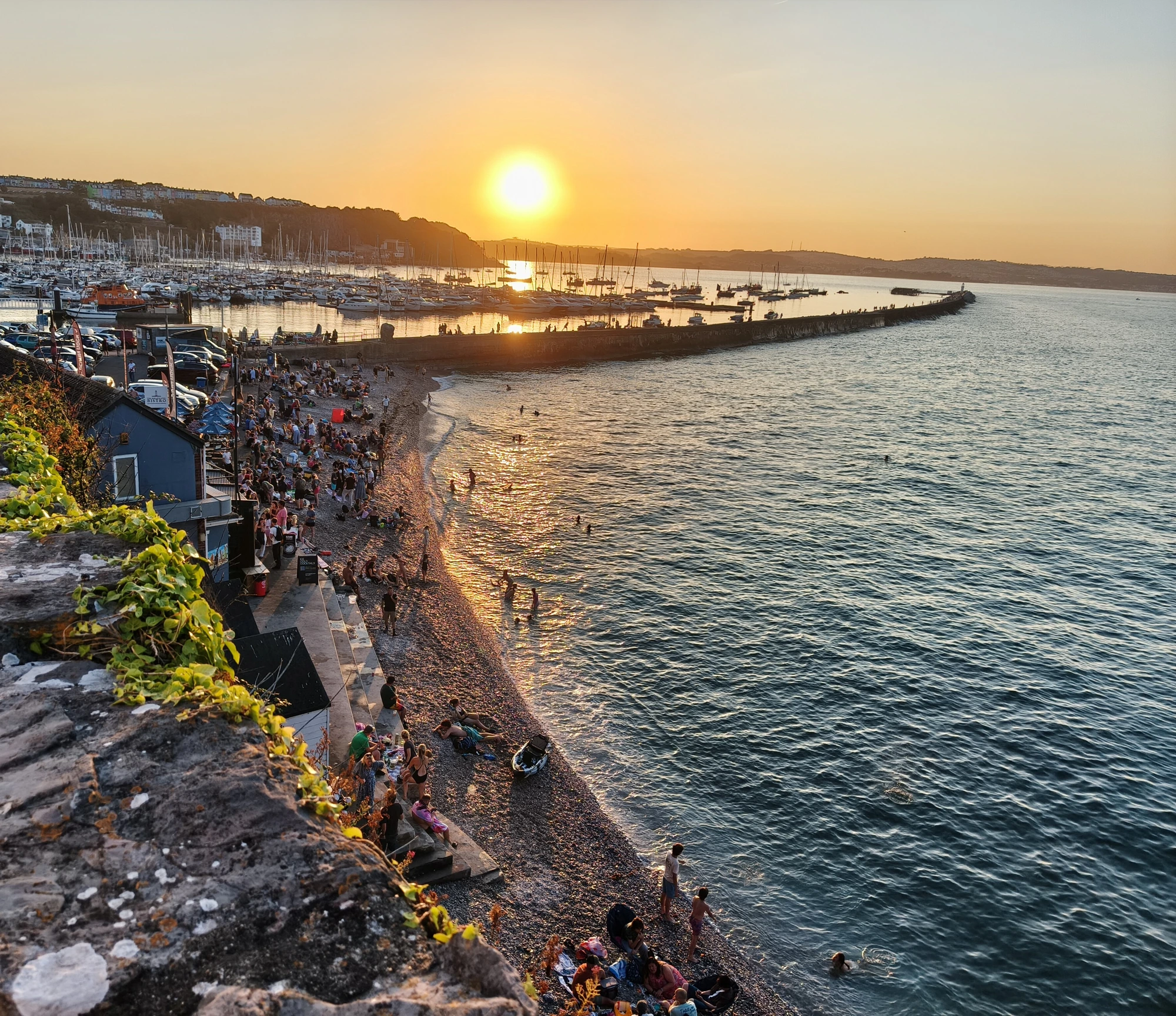 Beautiful sunset over South Devon harbor with boats and coastline